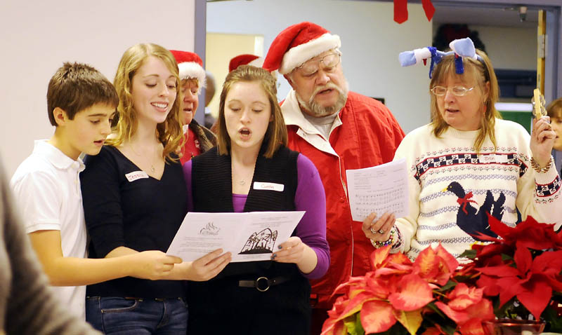 Guests and volunteers sing Christmas tunes Sunday during the community meal served at the Prince of Peace Lutheran Church in Augusta.