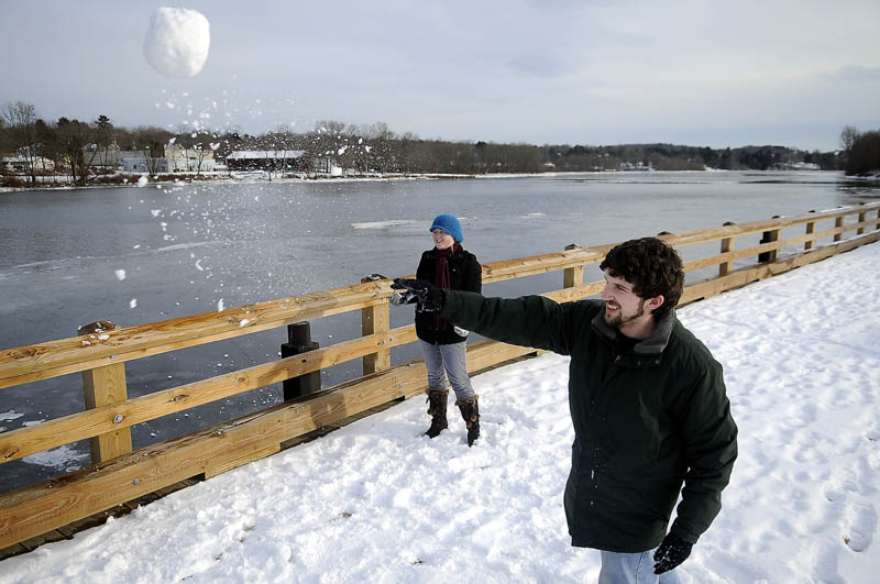 TAKE THAT! Josh Canty and Rachael Harris launch snowballs Tuesday at the boat landing on the Kennebec River in Gardiner. Canty, a resident of the Republic of Mexico, and Harris, a resident of the Marshall Islands, attended Gardiner Area High School together and were flinging snow at their buddy, Jeremy Sales, during a break at home.