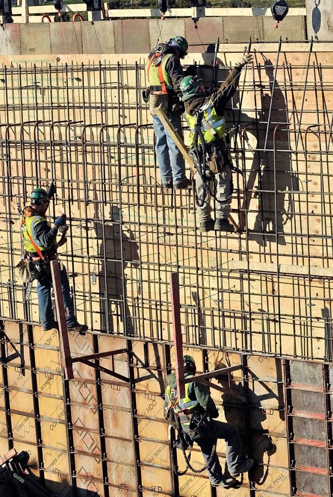 NO FEAR OF HEIGHTS: Newman Concrete Services workers tie together reinforcing bars for a concrete retaining wall Wednesday at the new MaineGeneral regional hospital construction site in Augusta.