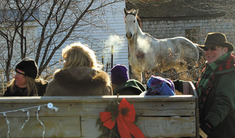 A horse watches a sleigh go by on Oak Grove Road in North Vassalboro during the 2nd annual Cowboy Christmas Parade on Sunday.