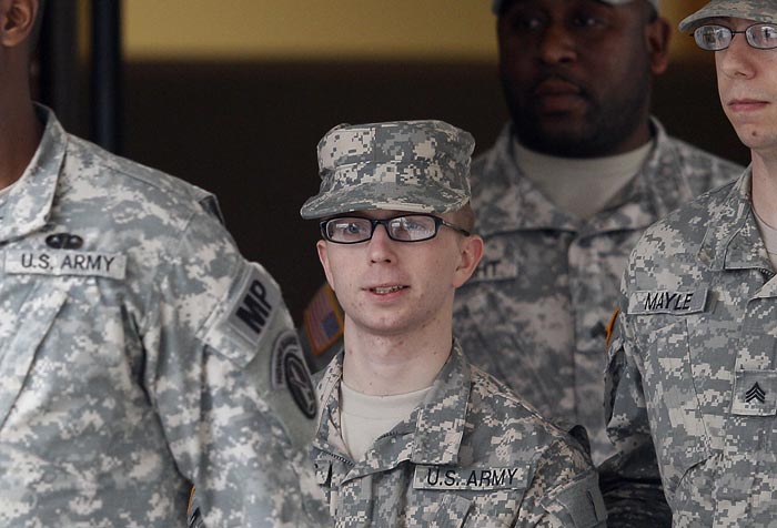 Army Pfc. Bradley Manning, center, is escorted out of a courthouse in Fort Meade, Md., today after a military hearing that will determine if he should face court-martial for his alleged role in the WikiLeaks classified leaks case.