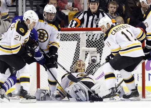 Boston Bruins goalie Tuukka Rask, center, lies on the ice as teammates Gregory Campbell (11), Daniel Paille (20) and Andrew Ference (21) move to clear the puck as Toronto Maple Leafs' Joey Crabb, rear left, looks for a shot in the second period Saturday in Boston.