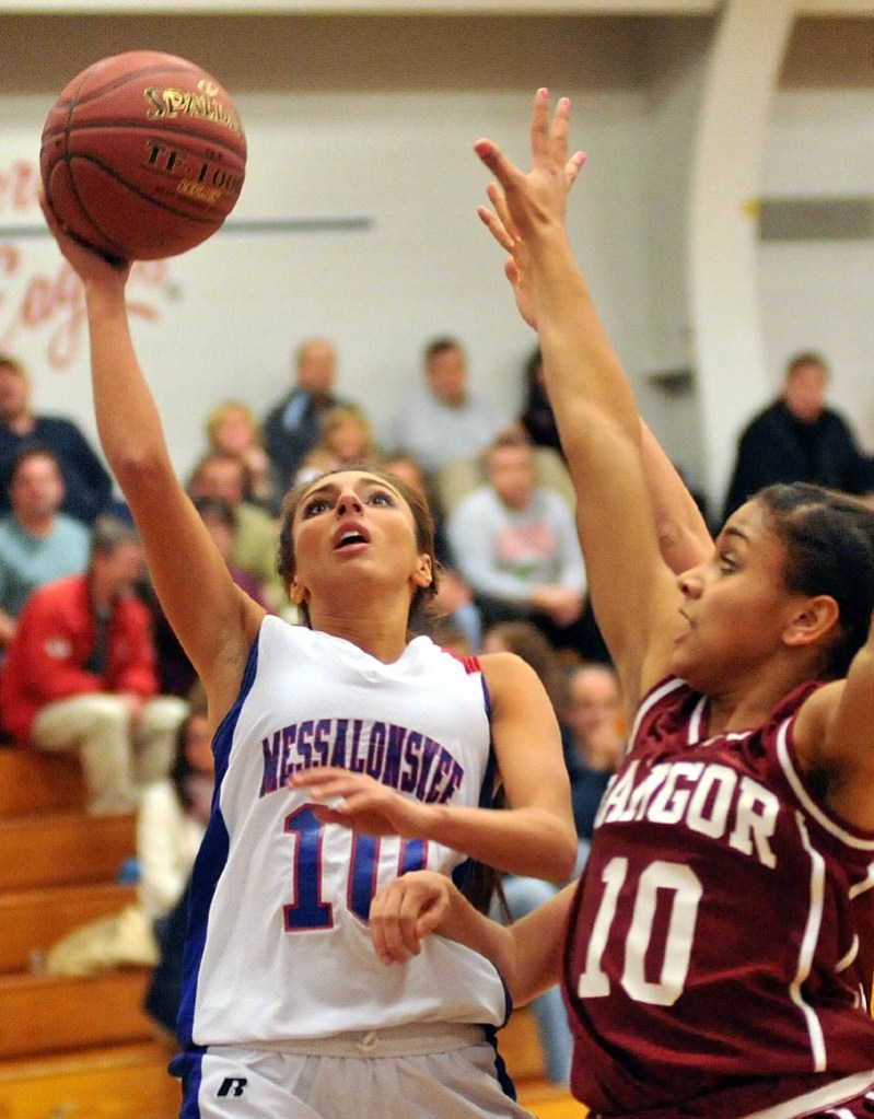 TO THE HOOP: Messalonskee High School’s Mary Badeen, left, drives for a layup while Bangor High School’s Denae Johnson plays defense in the first half of their game Tuesday in Oakland.