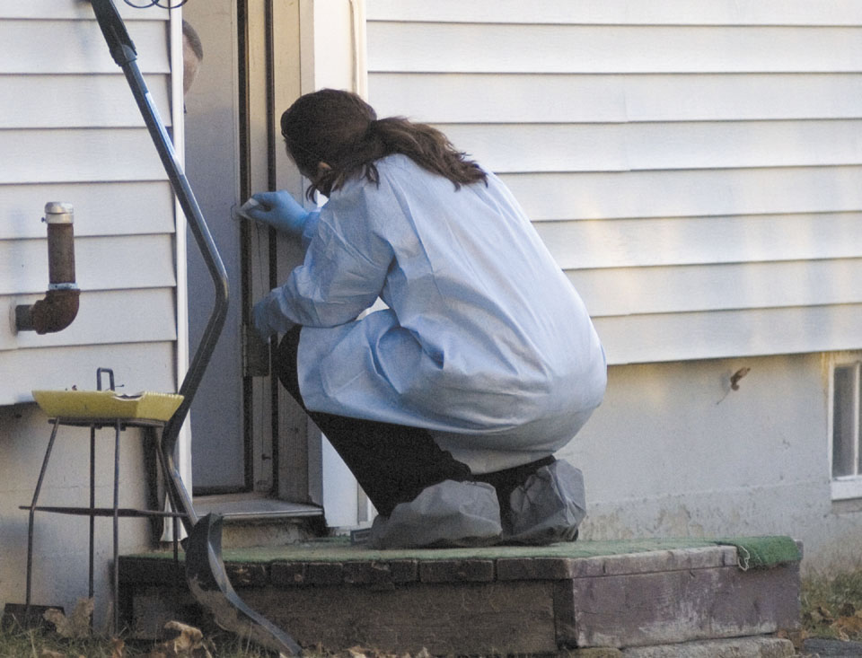 A Maine State Police reconstruction team takes samples Tuesday from the edge of the doorway into the home where 20-month-old Ayla Reynolds was last seen on Violette Avenue in Waterville.