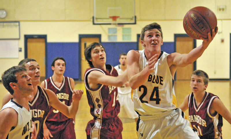 TO THE HOOP: Mt. Blue High School’s Eric Berry (24) drives to the hoop against Bangor High School defender Collin Kimsey, center, in the first quarter Tuesday at Mt. Blue Middle School in Farmington.