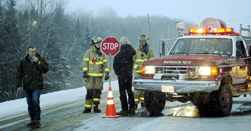 People wait Sunday for volunteer firefighters to re-open Route 3 in Palermo after two vehicle accident claimed the lives of four people. Firefighters shut the road and bypasses through Palermo while the accident was reconstructed.