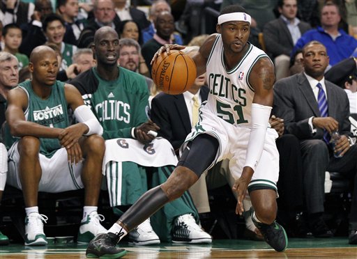 Boston Celtics guard Keyon Dooling (51) handles the ball as teammates, from left, Ray Allen, Kevin Garnett, and head coach Doc Rivers, right, watch from the bench during the first half Wednesday against the Toronto Raptors in Boston.