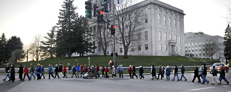 Members of local church congregations walk Sunday past the Capitol in Augusta during a silent march to show solidarity with Occupy Augusta members at Capitol Park.