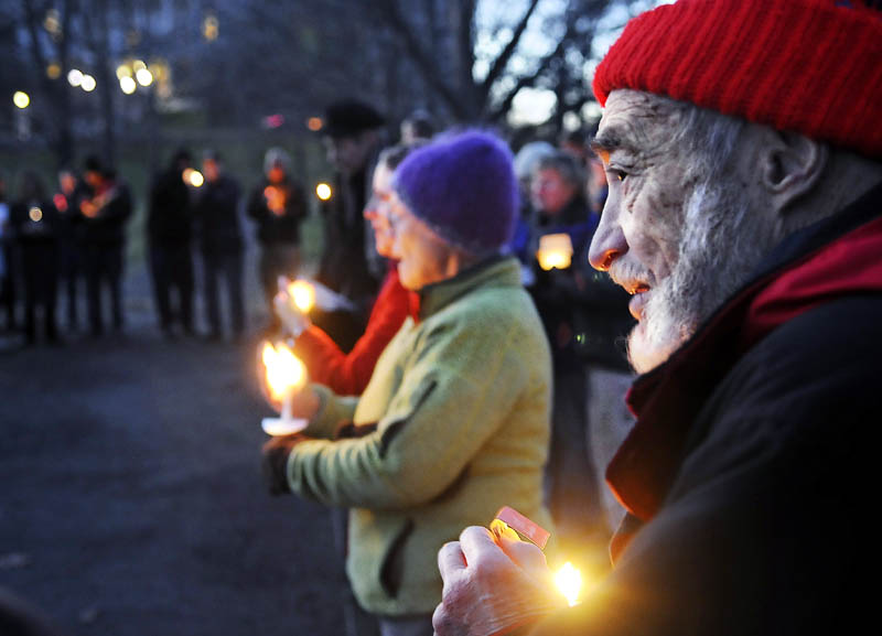 Charles Acker, of Whitefield, holds a candle Sunday during a vigil with members of several local church congregations to show solidarity with the Occupy Augusta members at Capitol Park in Augusta.