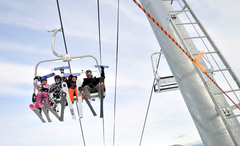 GOING UP: From left to right, Meredith Strang Burgess, Doug Stewart, Chris Proulx and Chad Coleman are the first skiers to ride the new Skyline lift at Sugarloaf Mountain on Saturday morning. Saturday was the first day of operations for the rebuilt lift that was closed after last season’s lift accident.