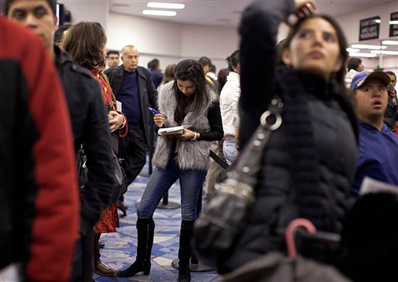 Non-resident visitors from an international flight fill out customs forms while waiting in line at immigration control at McCarran International Airport, Tuesday, Dec. 13, 2011, in Las Vegas. (AP Photo/Julie Jacobson)