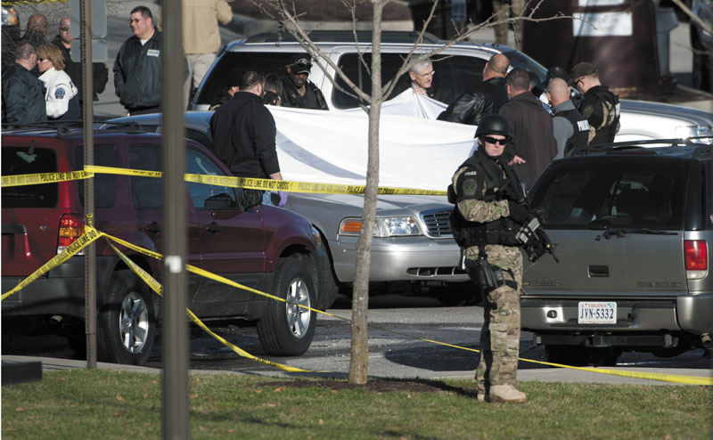 Authorities examine the body Thursday of a police officer shot to death in a parking lot on the campus of Virginia Tech in Blacksburg, Va.