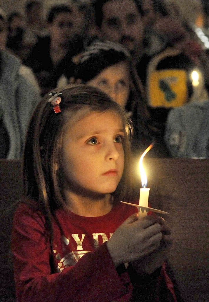 Katy Taylor, 5, holds a candle during the Vigil Of Hope For Ayla Reynolds organized by The Mainely Moms & Dads Wednesday evening in the First Congregational Church in Waterville.