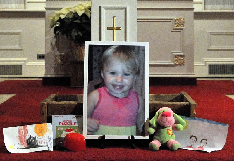 A photo of missing 20-month-old Ayla Reynolds sits on the altar at the First Congregational Church in Waterville during the "Vigil Of Hope For Ayla Reynolds" Wednesday night.