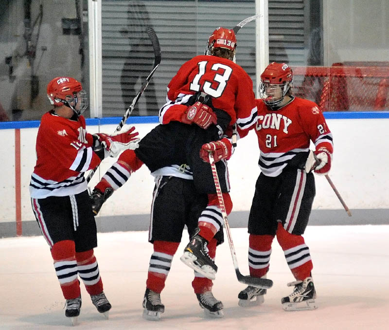 JUMPING FOR JOY: Cony High School’s Galen Casey (13) jumps into the arms of teammate Kiefer Cantara as teammates Zach Gagne, left, and Dakota Bowie watch after the Rams scored a goal against Waterville Senior High School on Wednesday in the first period at Alfond Rink at Colby College in Waterville.