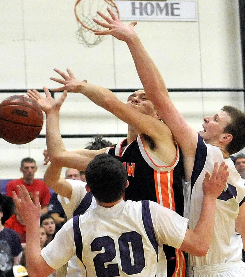 Winslow High School's Brandon Labrie, center facing, is fouled by Waterville High School's J.P. Michaud, right, as teammate Brandon Braley tries to defend in the second quarter at Waterville Senior High School Friday night.