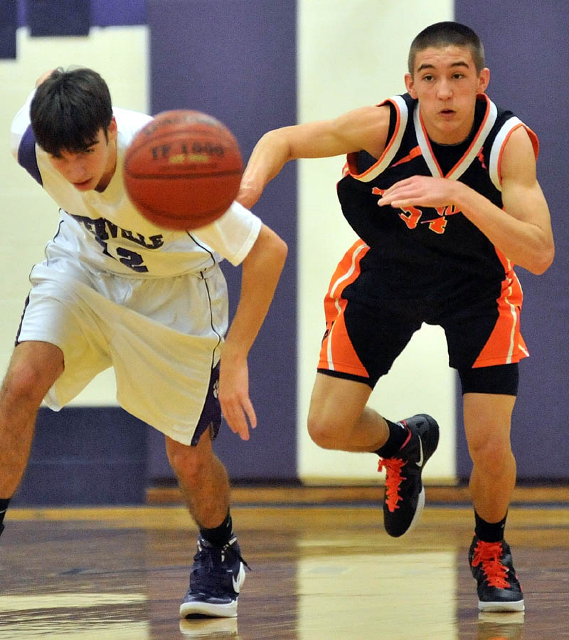 Waterville Senior High School’s Justin Jabar, left, and Winslow High School's Nason Lanphier chase a loose ball in the first quarter Friday in Waterville.