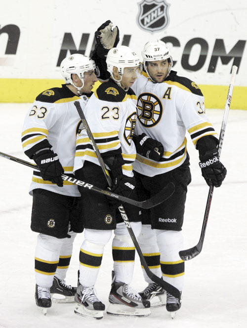 NICE WORK, BUDDY: Boston’s Brad Marchand (63), Chris Kelly (23) and Patrice Bergeron (37) celebrate Kelly’s goal during the Bruins’ 5-3 win over Columbus on Saturday in Columbus, Ohio.