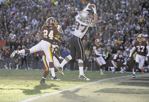 OVER THE TOP: New England Patriots tight end Rob Gronkowski (87) catches a touchdown pass over Washington Redskins strong safety DeJon Gomes (24) during the first half Sunday in Landover, Md. Gronkowski finished with six catches for 160 yards and two touchdowns. He is now the NFL leader in touchdowns in a single season by a tight end with 15.