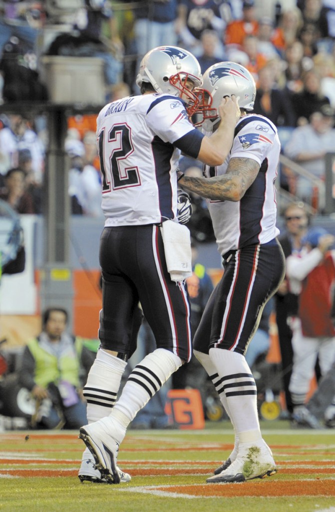 ONE TITLE DOWN: New England Patriots quarterback Tom Brady, left, celebrates with tight end Aaron Hernandez during the Patriots’ 41-23 win over the Denver Broncos on Sunday. With the win, New England clinched its ninth AFC East title in 11 seasons.