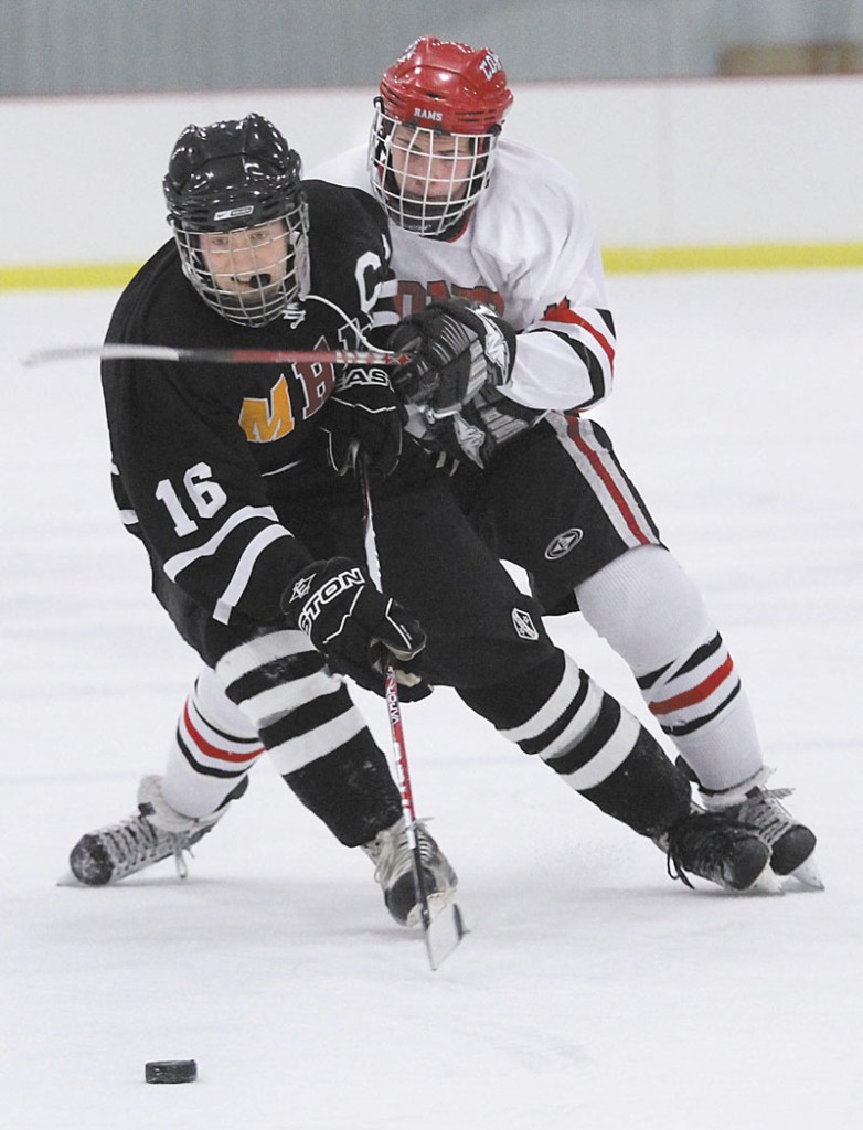 A STICKING POINT: MHW forward Tyler Bryant (16) battles for the puck with Cony High School’s Austin Davis during the first period of Monday’s game in Kents Hill.