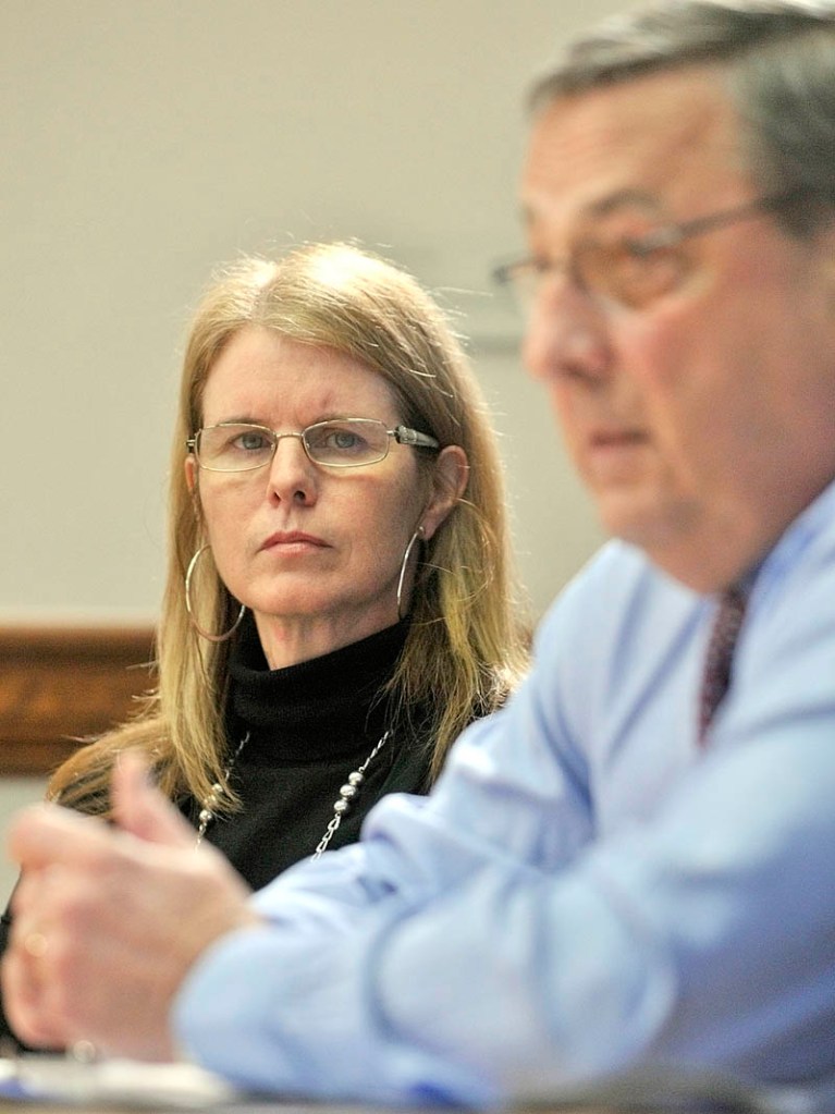Department of Health and Human Services commissioner Mary Mayhew, left, listens to Gov. Paul LePage during a news conference on Thursday in the State House in Augusta.