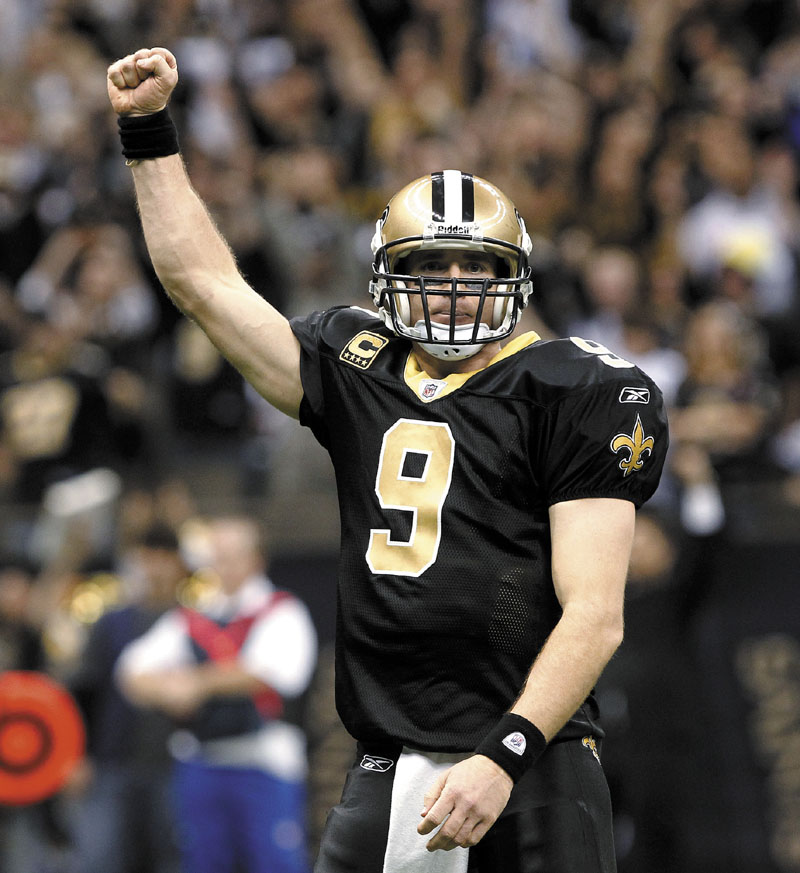 RECORD SETTER: New Orleans Saints quarterback Drew Brees celebrates after throwing a touchdown pass and breaking the NFL single-season record for passing yardage held by Dan Marino on Monday in New Orleans. NFLACTION11;