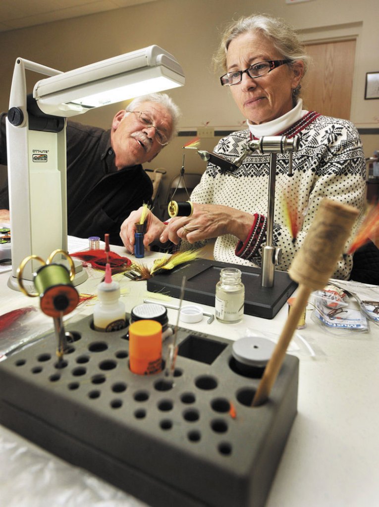 LEARNING THE TRICK OF THE TRADE: Evelyn King and her Mickey Finn get some much-appreciated attention from Lane Soltesz, a fisherman for 40 years. Both of them are benefiting from fly tying class.