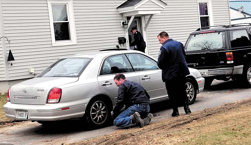 LOOKING FOR EVIDENCE: Maine State Police Detective Scott Bryant watches as a tow truck operator hooks on to the first of two vehicles that were taken from a home at 29 Violette Ave. in Waterville today. The home has been subject to an intense investigation for 20-month-old Ayla Reynolds, who has been missing since last Friday. The girl and her father, Justin DiPietro, live at the home.