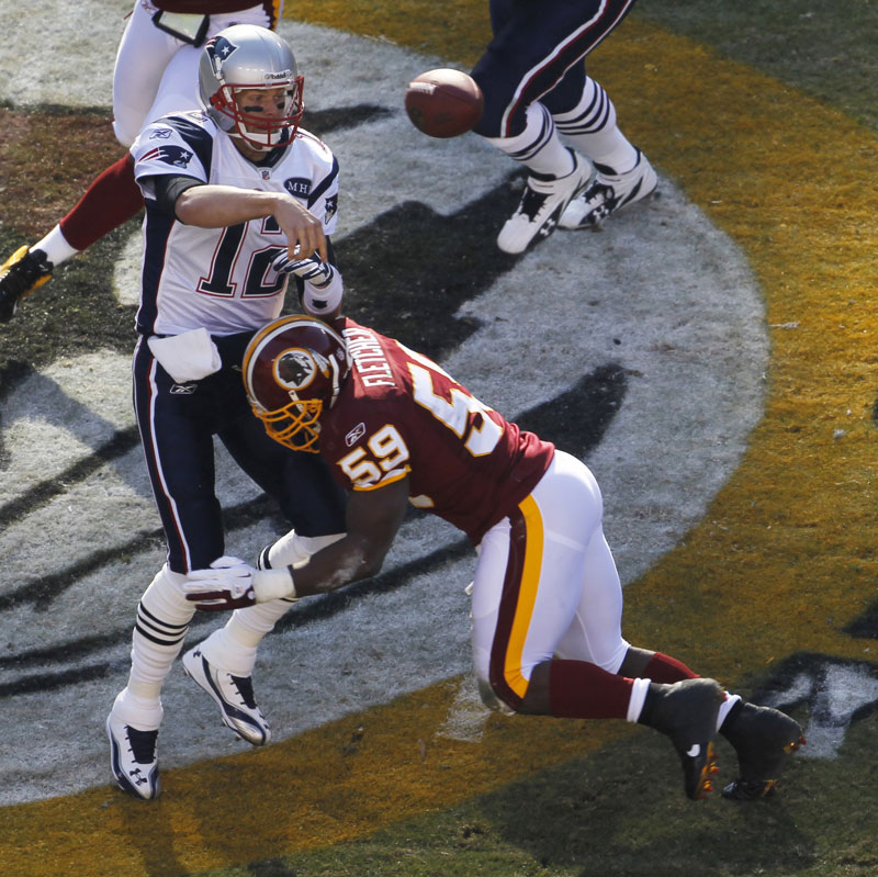 GET THE THROW OFF: New England quarterback Tom Brady (12) is hit by Redskins linebacker London Fletcher in the first half of the Patriots’ 34-27 in Landover, Md.