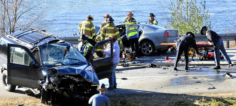 HECTIC SCENE: Police and fire officials investigate the chaotic scene of a head- on collision of two cars on U.S. Route 2 near the eddy in Skowhegan on Thursday. Both seriously injured drivers of each vehicle were pinned inside.