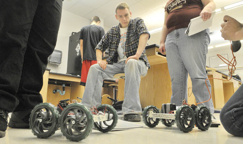 Brandon McCutcheon, center, watches as his classmates run their robots on Thursday morning at Cony High School in Augusta.