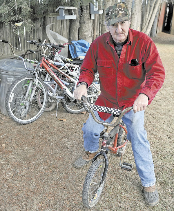 BIKE SHOP: Hugh Breingan sits on a bicycle he plans to repair at his Skowhegan home.