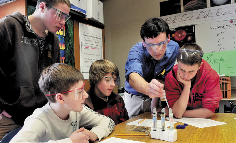 GOOD CHEMISTRY: Colby College student Ben Bricker assists Lawrence Junior High School students during a science exercise on Tuesday. From left are Max Davidson, Alex Hayes, Iyan Blaisdell, Bricker and Jacob Dickson. Bricker and fellow student Teko Mmolawa are enrolled in a college program designed to offer student-initiated academic programs under faculty supervision.