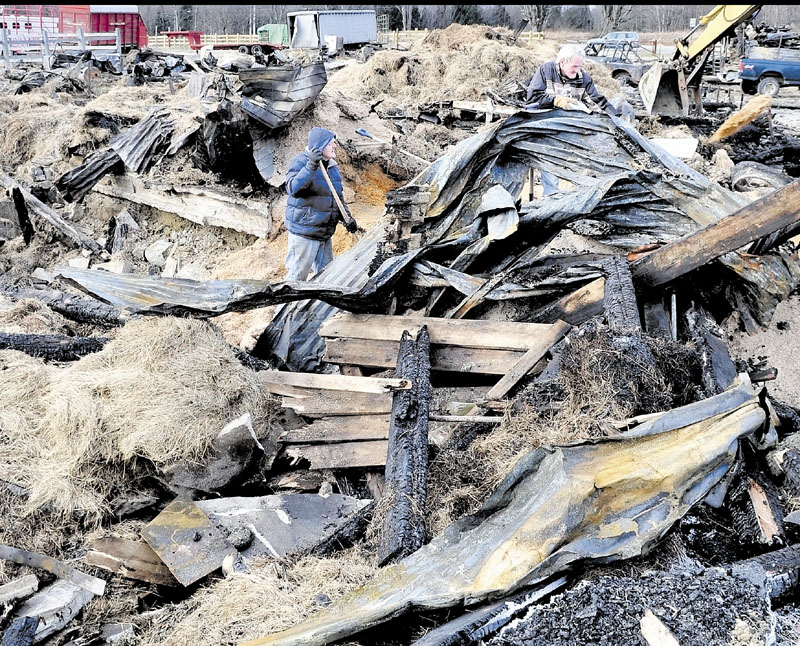 SALVAGE: Bill Thrasher, left, and his brother Jim salvage sawdust from the ruins of a barn at the Knowlton Corner farm in Farmington on Wednesday.