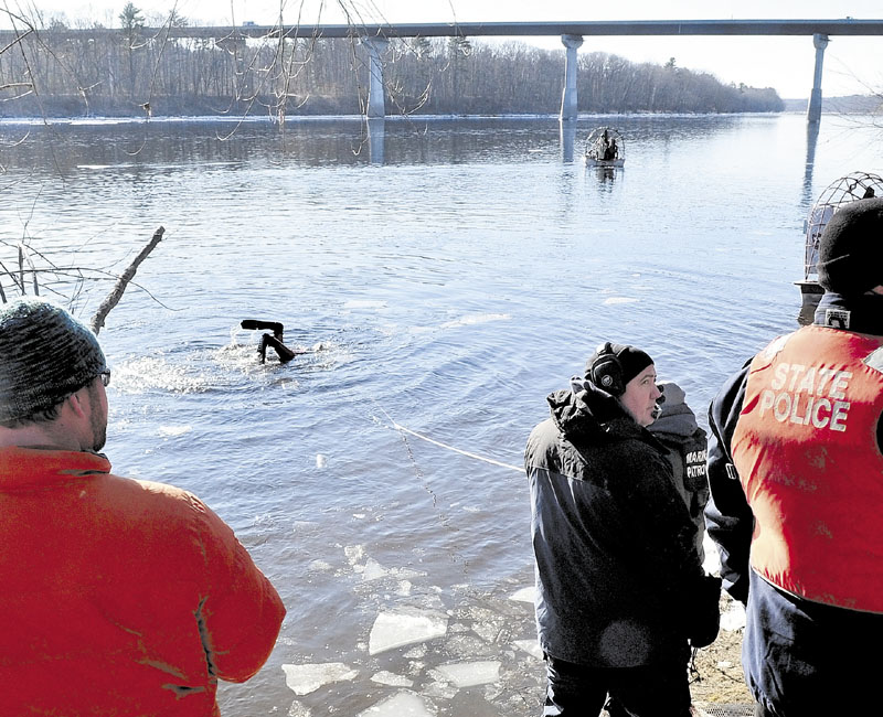 INTO THE COLD: A diver heads back underwater as a search boat motors above the Carter Memorial Bridge in the Kennebec River as state police and the Maine Warden Search conducted an extensive search of the river for signs of missing toddler Ayla Reynolds on Wednesday.