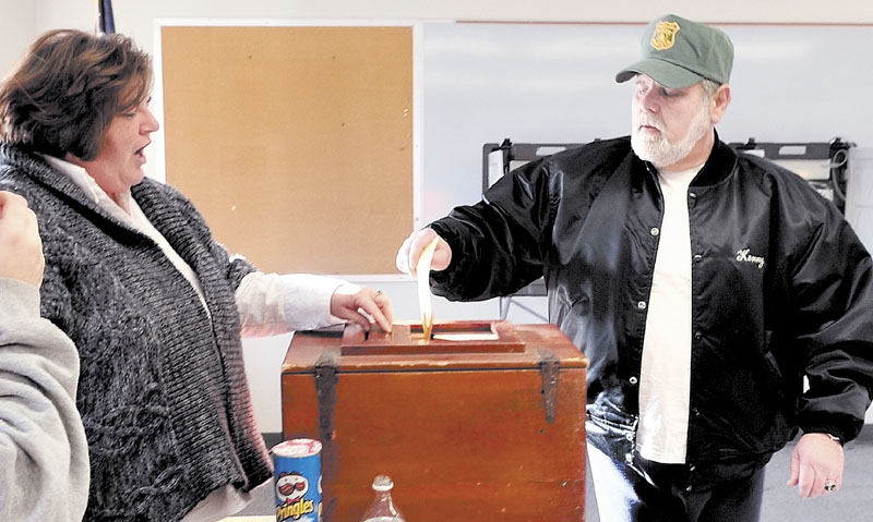 CIVIC DUTY: Starks resident Kenneth Laux casts his ballot as ballot clerk Tracy Quimby monitors voting at the Starks Community Center on Tuesday. Residents voted to secede from School Administrative District 59 and send students to Mt. Blue's school district.