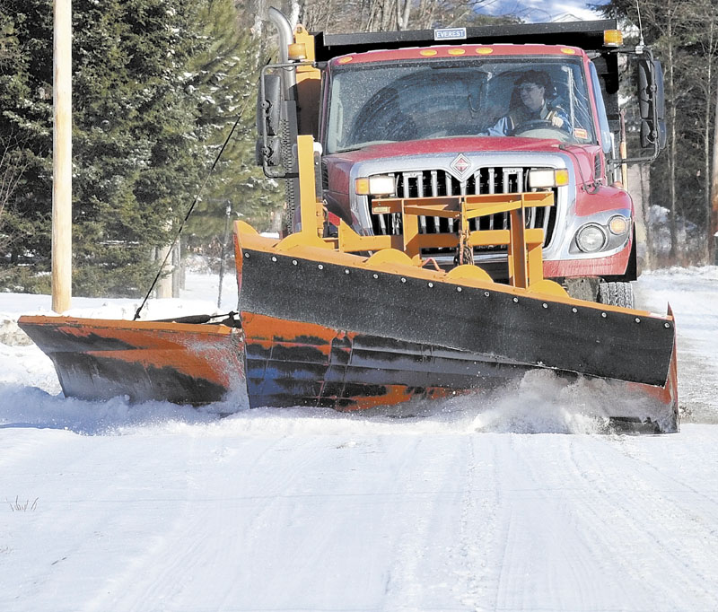 SCRAPER: The operator of a town of Norridgewock snowplow truck scrapes snow off Oosoola Road in town on Wednesday.