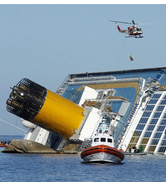 An Italian fireman descends from a helicopter to the Costa Concordia today.