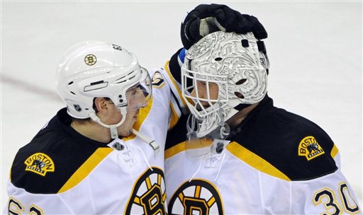 Boston Bruins' Brad Marchand (63) congratulates goaltender Tim Thomas (30) after the Bruins defeated the New Jersey Devils 6-1 Wednesday in Newark, N.J.