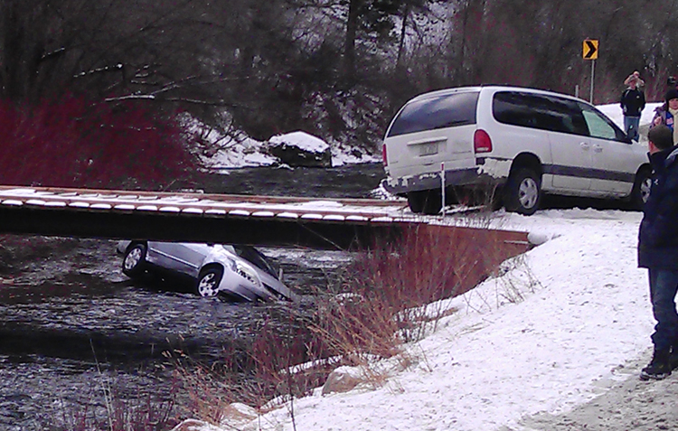 A photo provided by Chris Willden shows a car in the Logan River in Utah, after the car was flipped upright by rescuers who saved three children trapped in the car. The car plunged off an embankment into the river and Willden shot out the car's window with a handgun and cut a seat belt to help free the children after the accident.