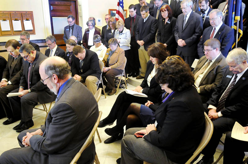 Legislators and state officials bow their head in prayer Tuesday during the Maine Call to Prayer event at the State House. Senate President Kevin Raye. R-Raye, front row left, Governor Paul LePage and Speaker of the House Robert Nutting, R-Oakland, signed the call to prayer document along with several legislators.