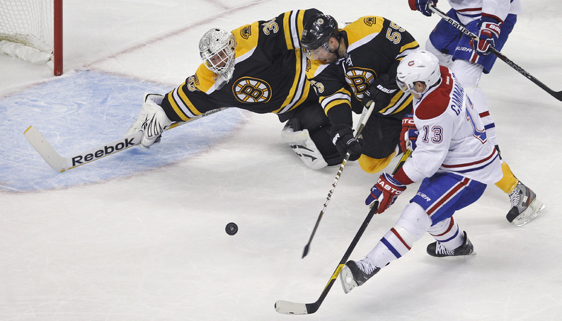 Bruins goalie Tim Thomas dives to make a save on a shot by Canadiens left wing Mike Cammalleri in the first period of their game in Boston on Thursday. At center is Bruins defenseman Johnny Boychuk.