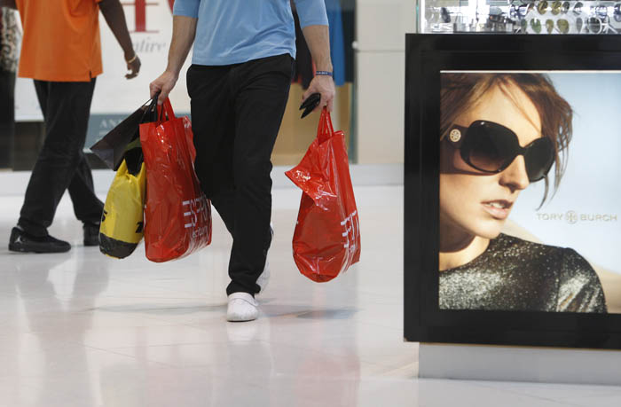 A shopper carries purchases at Dolphin Mall, in Miami, Fla., recently.