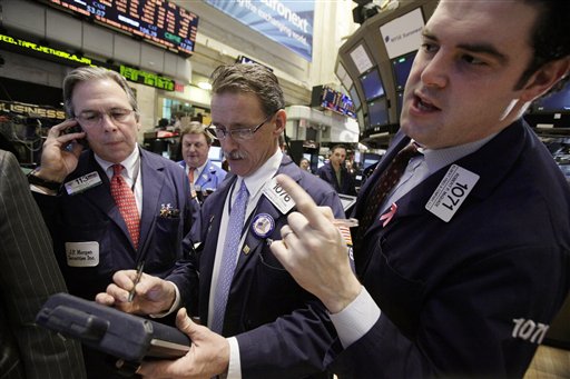In this Jan. 25, 2012 photo, traders Thomas Kay, left, Marshall Ryan, center, and Robert McQuade work on the floor of the New York Stock Exchange. (AP Photo/Richard Drew)
