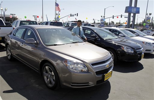 Chevrolet Malibus are lined up at a car dealership in San Jose, Calif., recently. Much of the fourth-quarter growth was powered by a 14.8 percent surge in sales of autos and other long-lasting manufactured goods.
