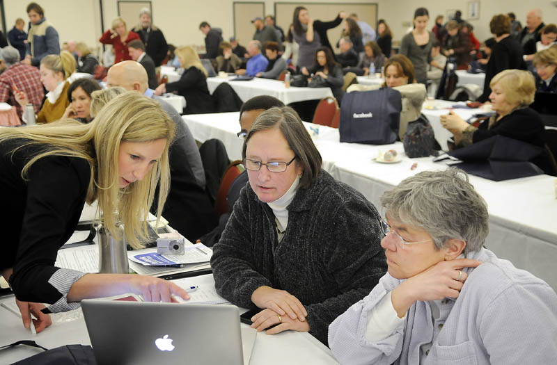 TECH SUPPORT: Facebook employee Kirsten Bury, left, helps Sandy Gnidziejko, center, and Ellen Heath arrange a page for their Biddeford business, Little River Antiques and Collecting, during a Tuesday forum by the internet social networking business in Augusta.
