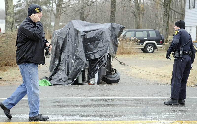 CRASH SCENE: Gardiner Police Chief James Toman, left, and officer Dan Murray investigate a rollover accident Saturday that took the lives of two men and injured a third on U.S. Route 201 in Gardiner. The accident occurred after 8 a.m. in icy conditions, according to Toman. Dennis Kay, 62, of Gardiner and Carlton Norwood, 25, of Pittston, died at the scene.