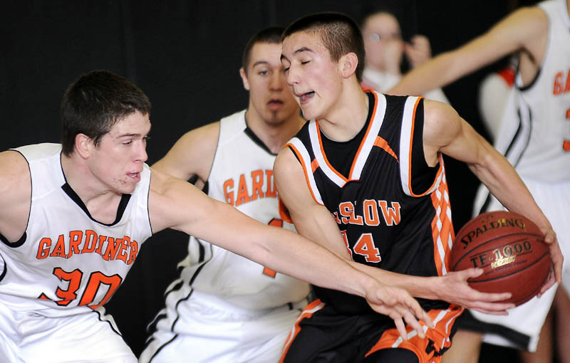 TIGHT DEFENSE: Gardiner Area High School’s Dennis Meehan, left, and Travis Kelley, center, defend against Winslow High School’s Nason Lanphier during a game Tuesday night in Gardiner.