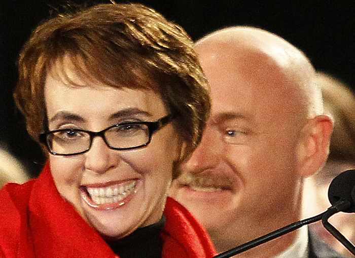 Rep. Gabrielle Giffords, accompanied by her husband, former astronaut Mark Kelly, reacts after leading the Pledge of Allegiance at the start of a memorial vigil on Jan. 8.